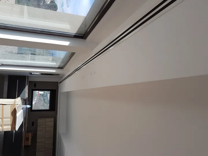 Γραμμικά στόμια κλιματισμού στην οροφή δίπλα σε υαλοστάσια