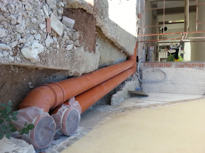 Υπόγειες σωληνώσεις δίπλα σε πέτρινο τοίχο