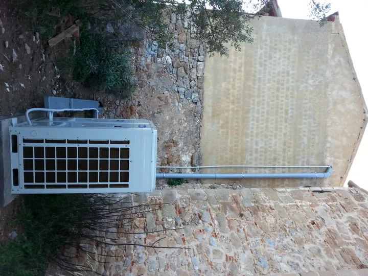 Εξωτερική μονάδα κλιματισμού στη βάση πέτρινου τοίχου